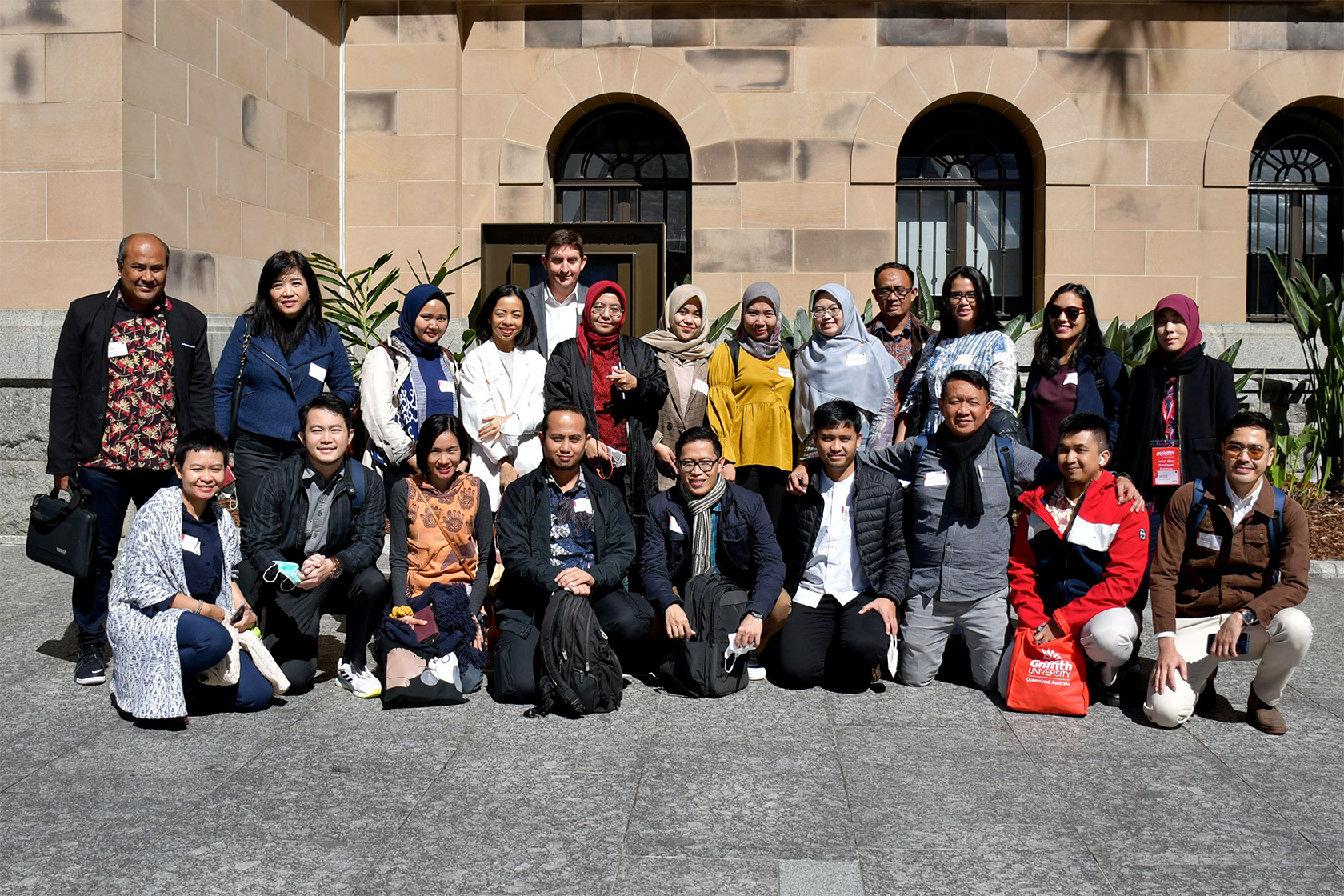 Participants take a photo together in front of a building
