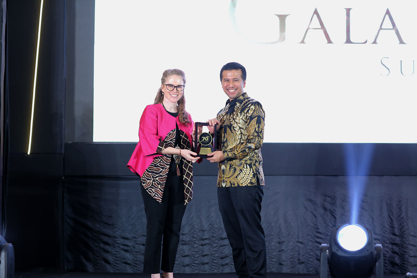 The Australian Consul-General in Surabaya Fiona Hoggart gives an award to Emil Dardak in honour of his father, the late Achmad Hermanto Dardak, former Vice Minister of Public Works A Touching Tribute: Australian Consul-General in Surabaya, Fiona Hoggart, presents an Award to Emil Dardak in honour of his late father, Achmad Hermanto Dardak, former Vice Minister of Public Works.