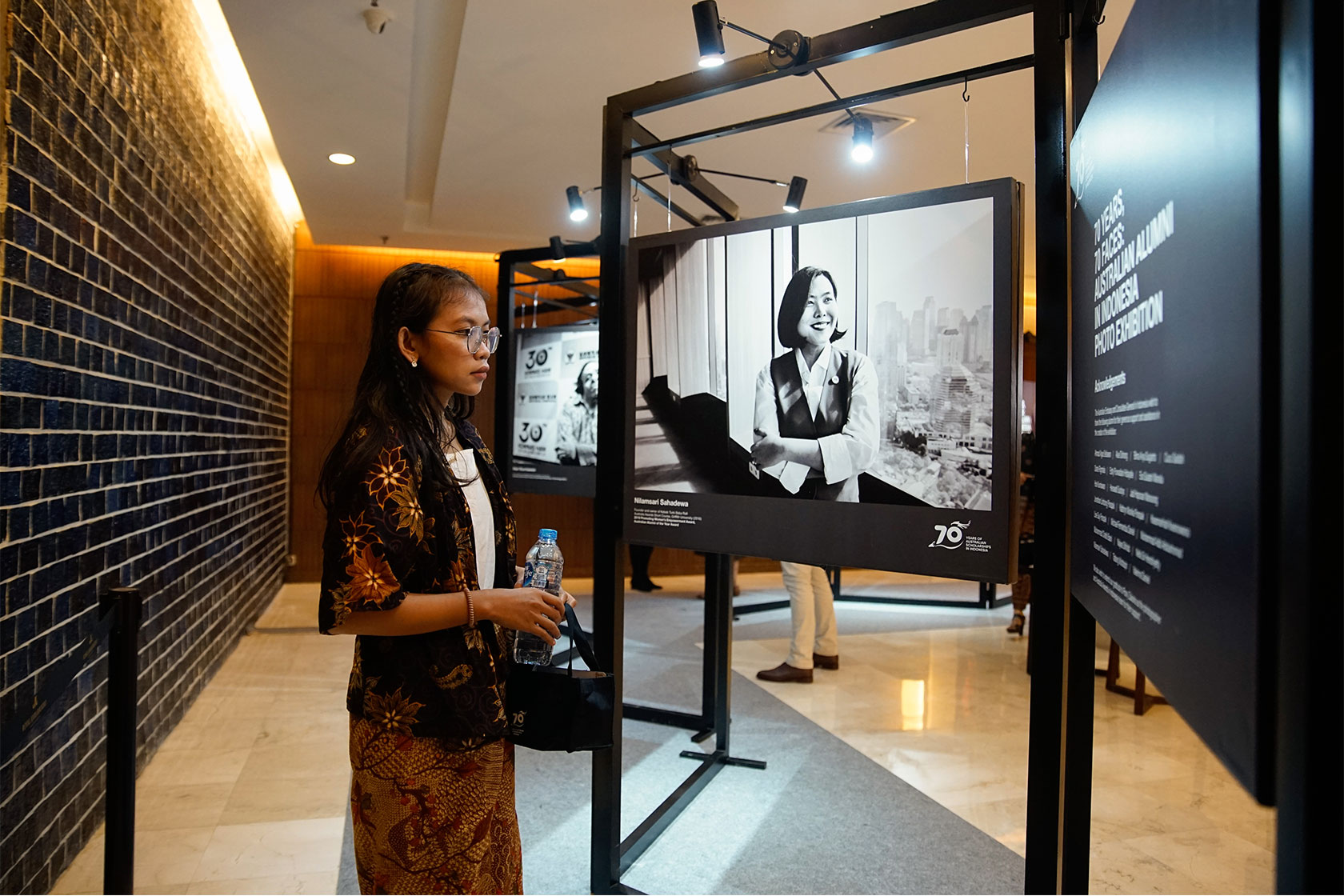 An alumna enjoys the mini-photo exhibition at the Gala Dinner in Yogyakarta