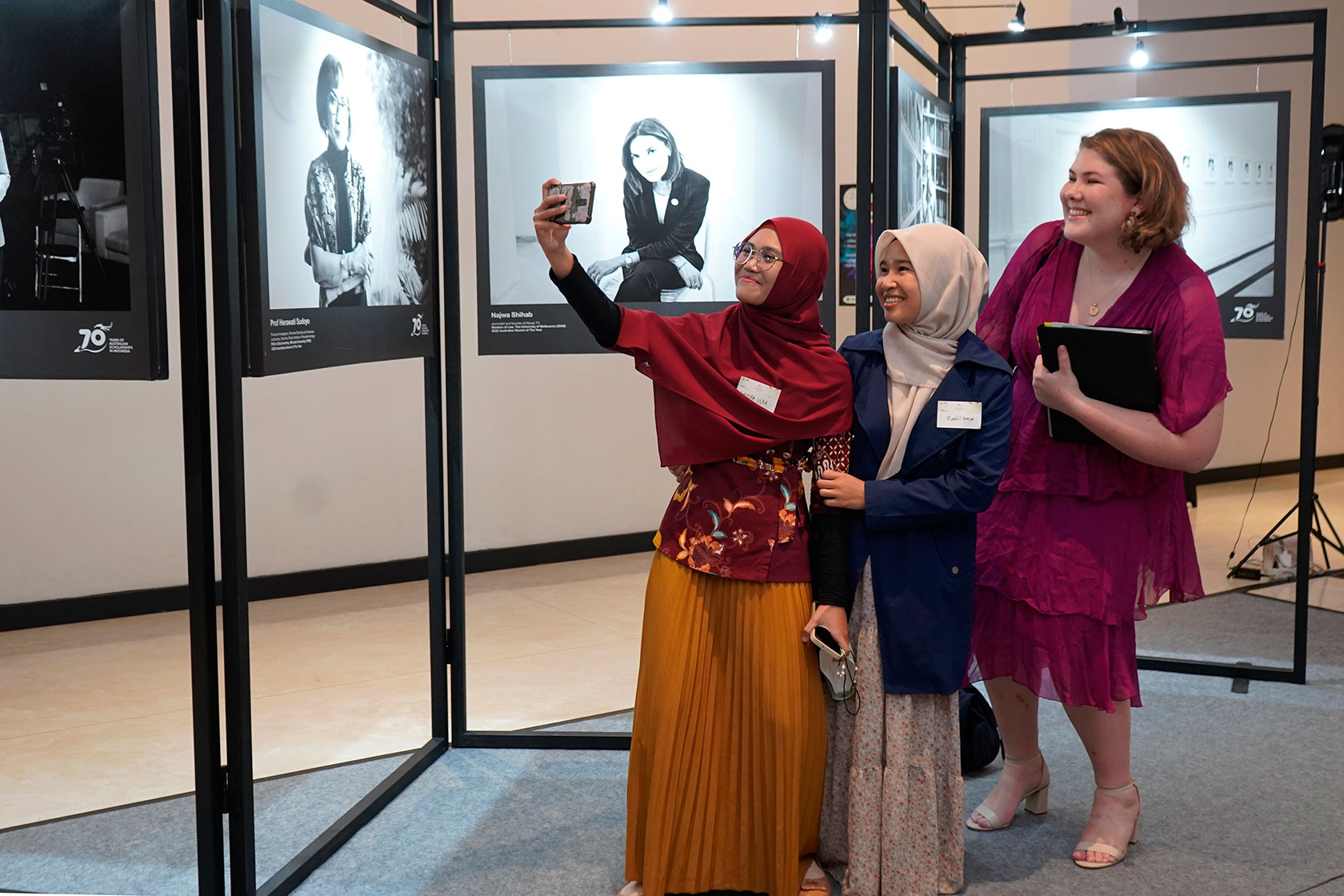 A group of Australian alumni take a selfie at the mini photo exhibition