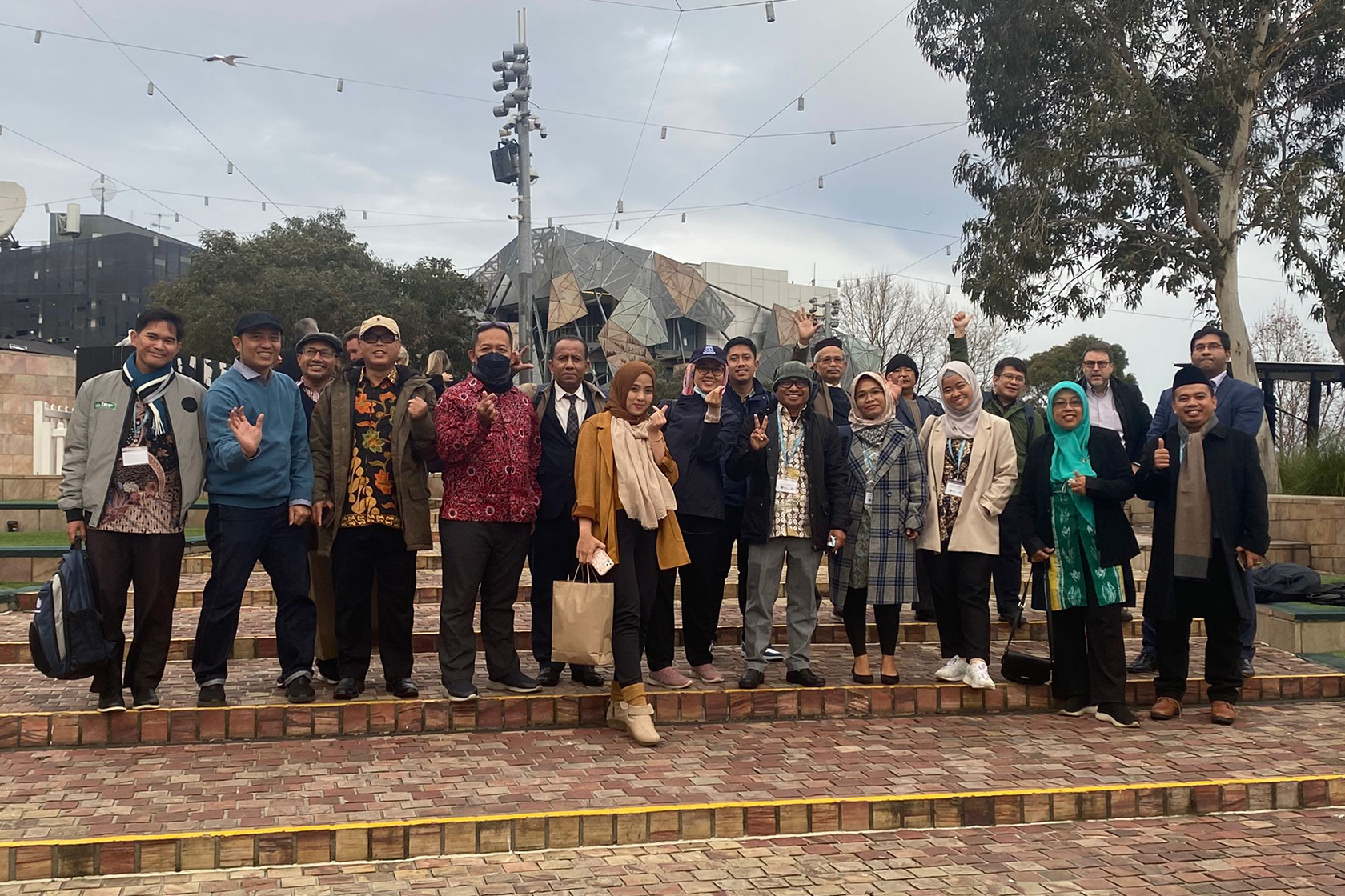 Participants take a group photo with the Australia Centre for the Moving Image in the background