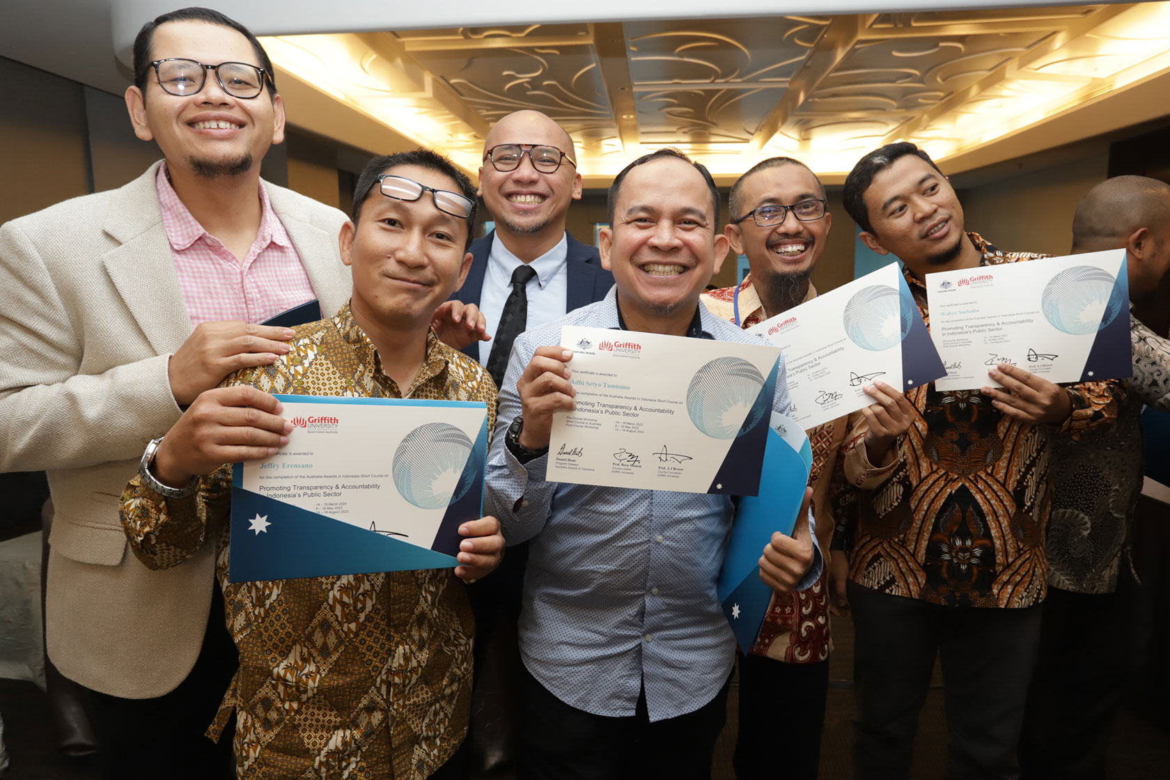 A group of male participants in this short course happily show their certificate of completion.