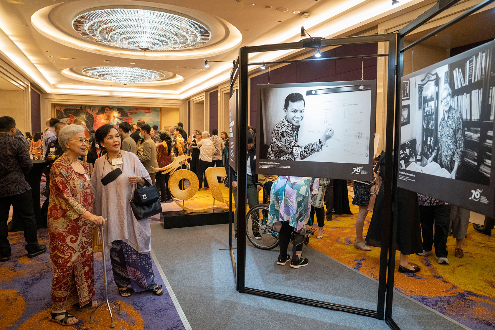 The 2023 Alumni of the Year Koesmarihati Koesnowarso sees her photo at the mini-photo exhibition alongside fellow alumna, Endang Tjempaka Sari Hartomo.