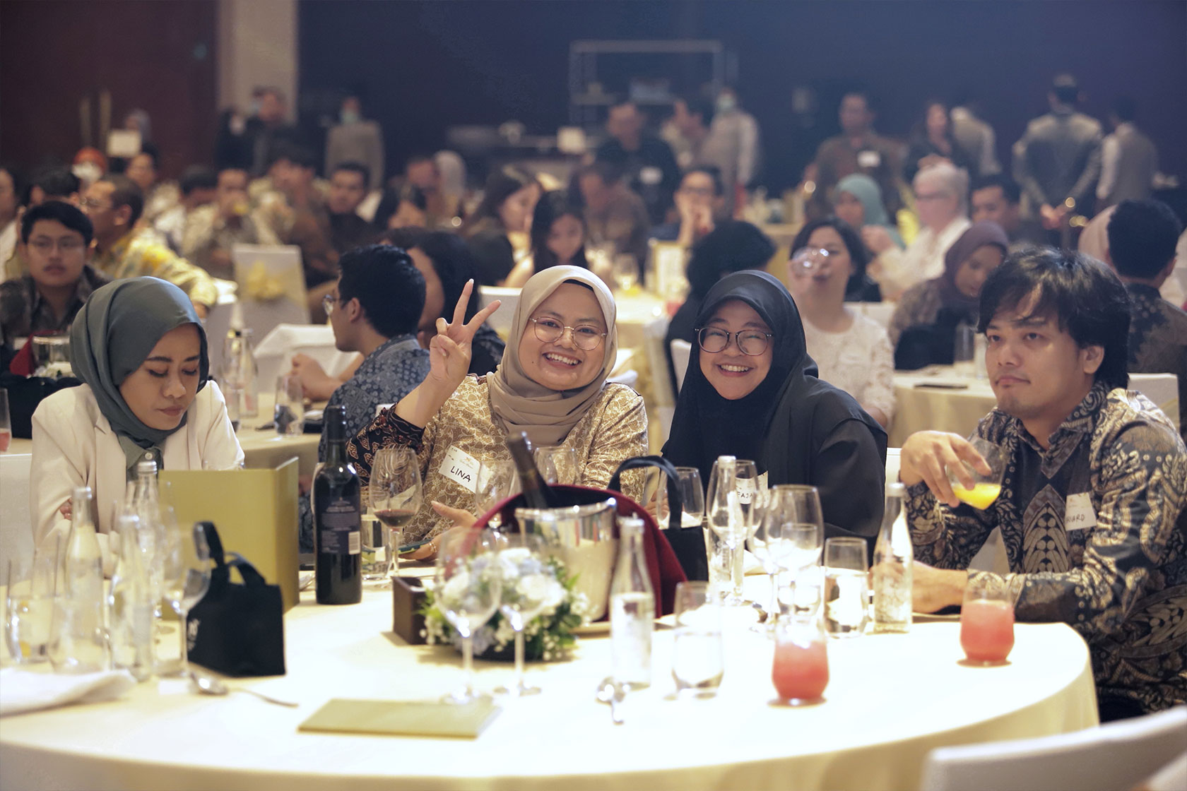Gala Dinner Jakarta attendees strike a pose, savoring delightful beverages and unforgettable moments.