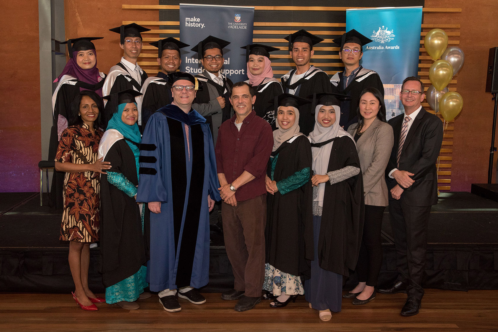SSMP graduates take a picture wearing graduation gowns with representatives of the University of Adelaide