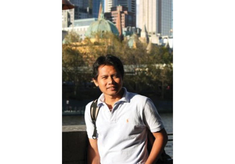 A man with white polo shirt standing outdoor