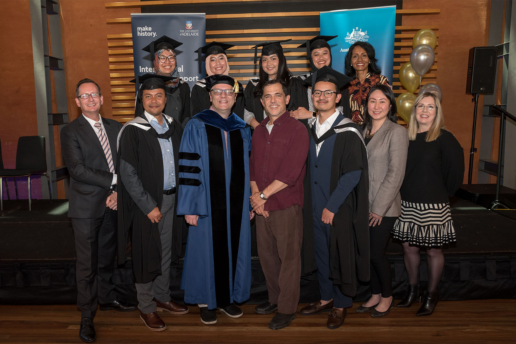 SSMP graduates take a picture wearing graduation gowns with representatives of the University of Adelaide